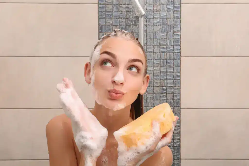 Woman Taking a Shower Holding a Sponge 